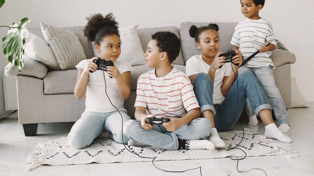 Crianças jogando videogame juntas em uma sala aconchegante
