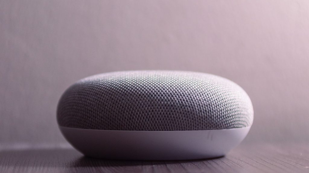 Caixa de som Bluetooth portátil em cima de mesa de madeira