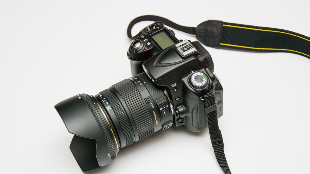 Câmera fotográfica Canon em close-up sobre superfície escura